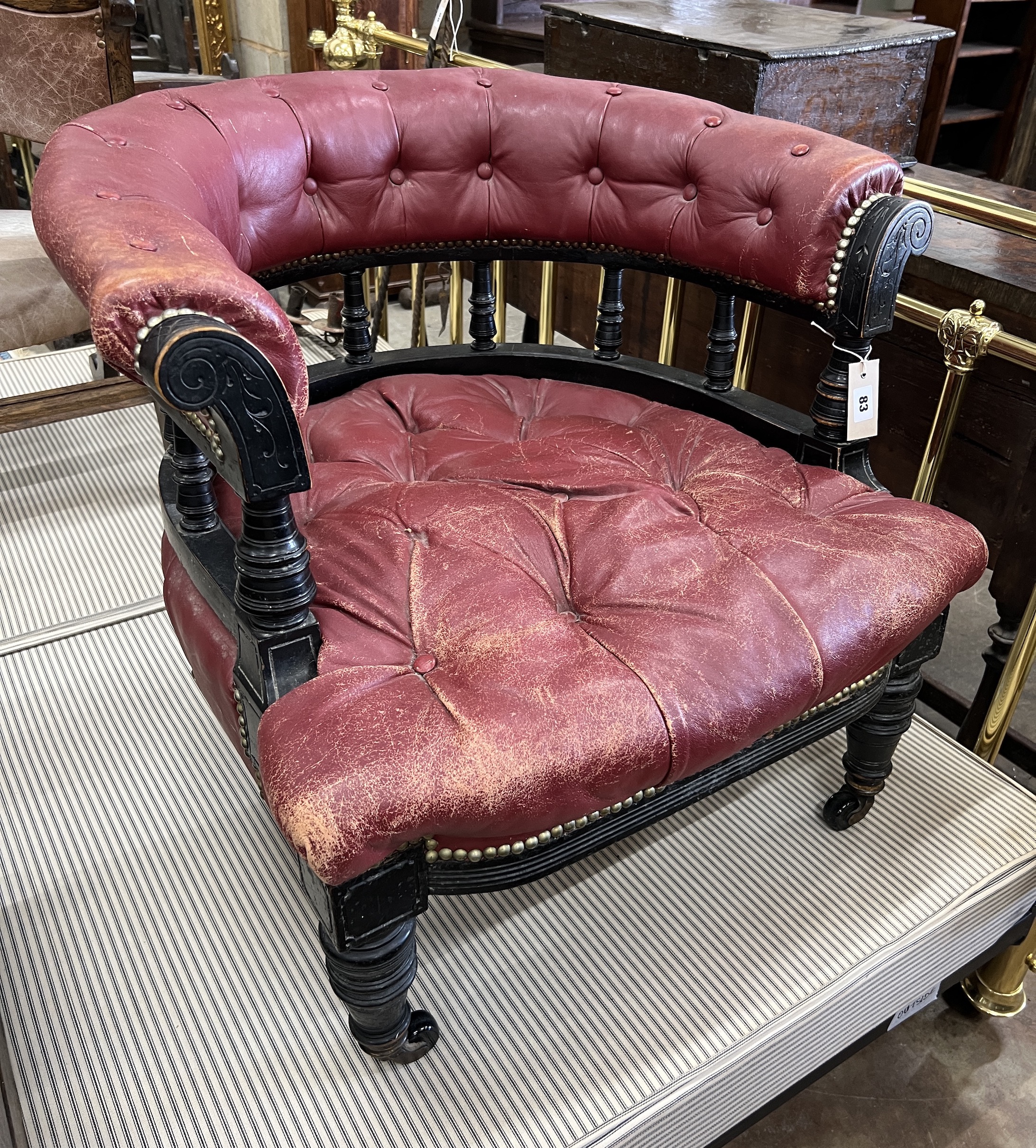 A late Victorian ebonised buttoned burgundy leather tub framed chair, width 66cm, depth 67cm, height 53cm